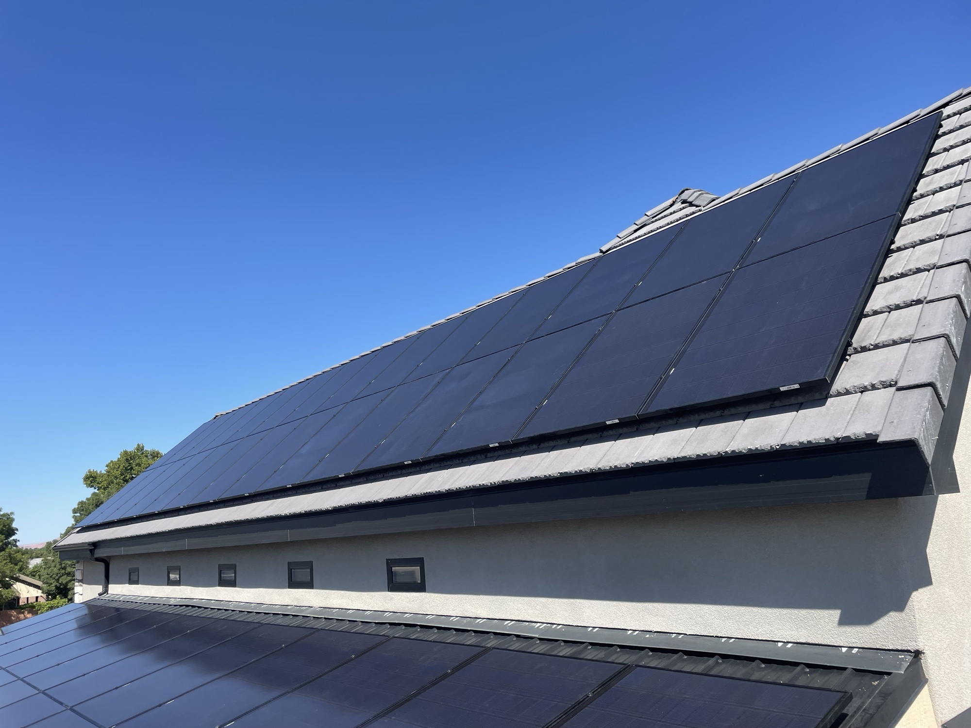 Black solar panels installed flush on a tile roof
